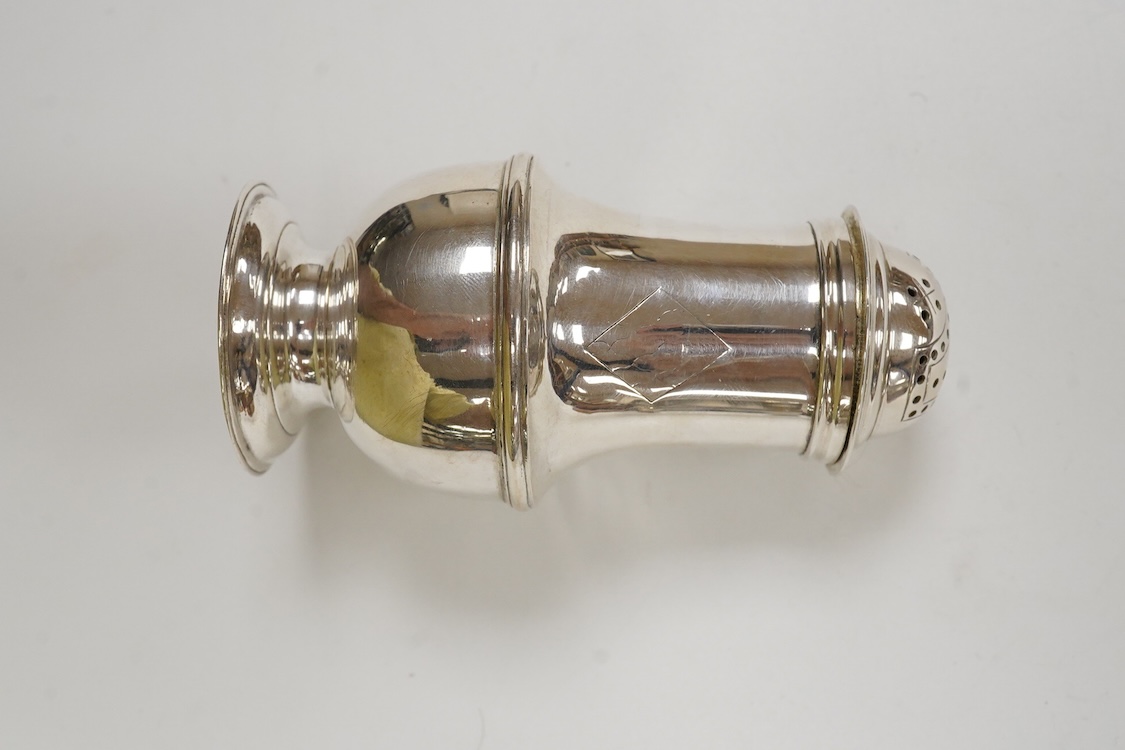 An early George II silver baluster pepperette, maker T?, London, 1734, with engraved crests, height 91mm, 82 grams.